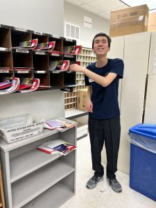 Boy smiling while sorting mail at Johnston Commons