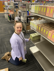 Girl smiling while restocking items at Penn State Bookstore
